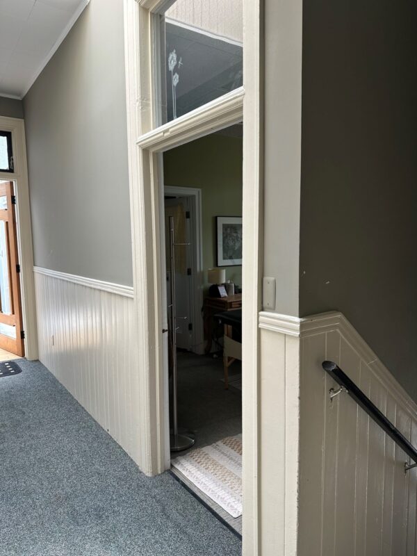 Open office door in hallway with carpet floor.