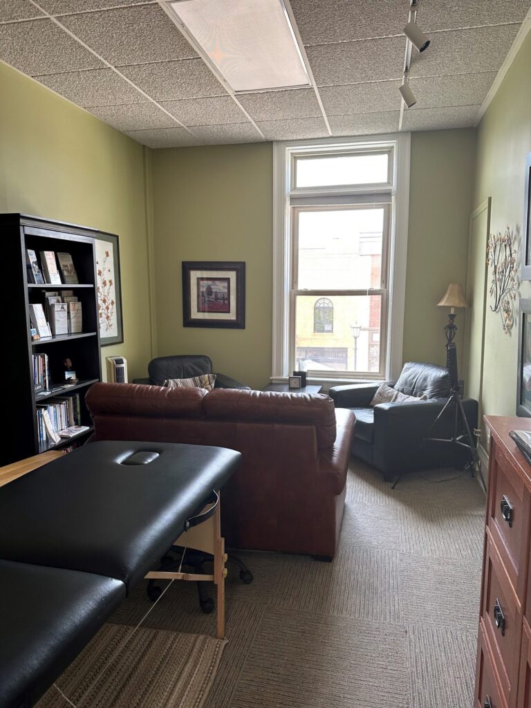 Cozy room with massage table and seating area.