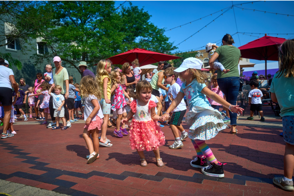 Children dancing outdoors in a lively group.